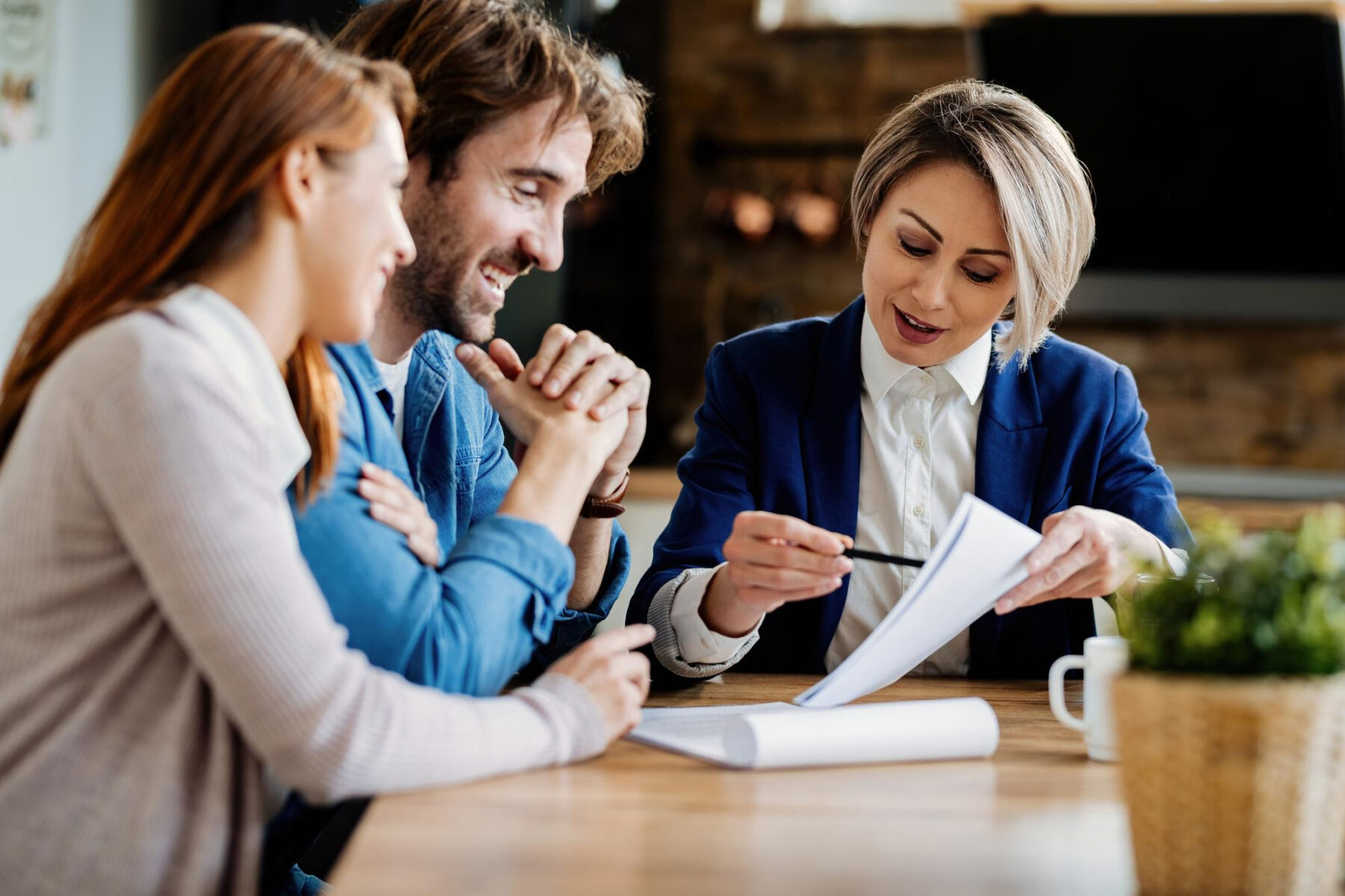 A loan officer reviewing paperwork with a couple at Legacy Loan in Las Cruces